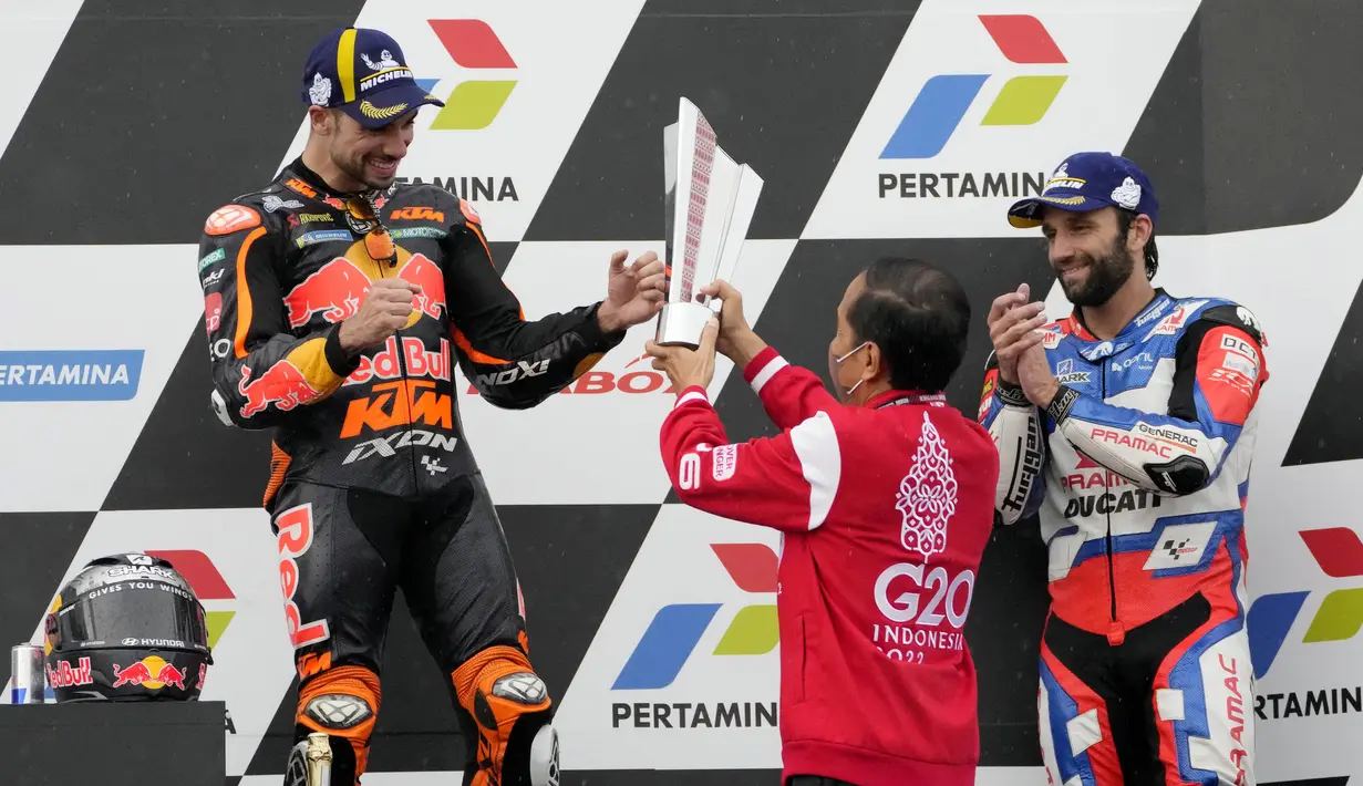 Presiden RI, Joko Widodo menyerahkan langsung trofi kepada pembalap KTM, Miguel Oliveira, yang naik podium MotoGP Mandalika di Sirkuit Mandalika, Lombok, Minggu (20/03/2022). (AP Photo/Achmad Ibrahim)