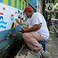 Warga menyelesaikan mural bertema Piala Dunia 2022 Qatar saat kegiatan Lomba Bucin Piala Dunia 2022 di Perum Depok Maharaja Blok M1 Cluster Cemara, Rangkapan Jaya, Depok, Minggu (30/10/20222). Emtek menggelar lomba hias kampung sebagai salah satu rangkaian program penunjang untuk Piala Dunia 2022 yang akan disiarkan di seluruh platform miliknya mulai 20 November hingga 18 Desember 2022 mendatang. (merdeka.com/Arie Basuki)