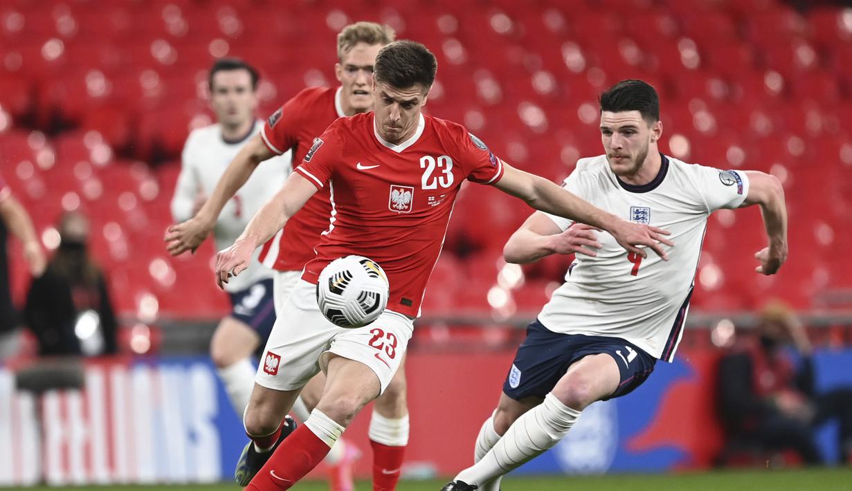 Striker Polandia, Krzysztof Piatek (kiri) menguasai bola dibayangi bek Inggris, Declan Rice dalam laga lanjutan Kualifikasi Piala Dunia 2022 Zona Eropa Grup I di Wembley Stadium, London, Rabu (31/3/2021). Polandia kalah 1-2 dari Inggris. (AP/Andy Rain)