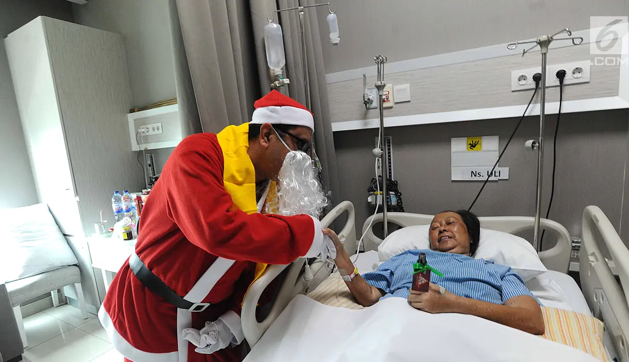 Seorang pria mengenakan kostum Santa Claus membagikan bingkisan Natal kepada pasien yang dirawat di RS Siloam, TB Simatupang, Jakarta, Kamis (21/12). Kegiatan ini dalam rangka menyambut perayaan Hari Natal 2017. (Liputan6.com/Joan)