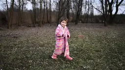 Seorang gadis muda mengenakan jubah saat melewati halaman belakang sebuah rumah bagi mereka yang melarikan diri dari Ukraina, di desa Uszka, Hungaria, 3 Maret 2022. PBB pada Kamis (3/3) melaporkan 1 juta orang telah meninggalkan Ukraina sejak invasi Rusia sepekan lalu. (AP Photo/Anna Szilagyi)