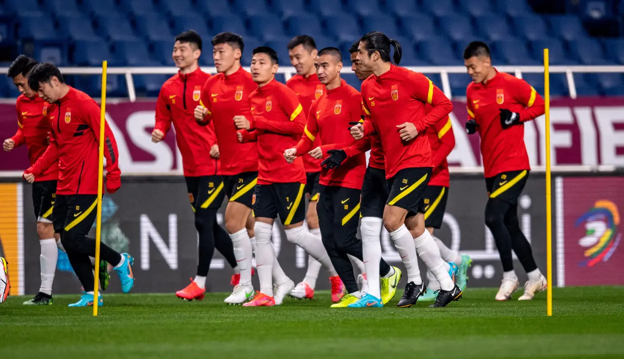 Para pemain China melakukan pemanasan saat mengikuti sesi latihan di Stadion Saitama, Jepang, Rabu (26/1/2022). China akan menghadapi Jepang pada Kualifikasi Piala Dunia 2022 Grup B Zona AFC. (AFP/Philip Fong)