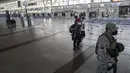 Seorang tentara dan beberapa penumpang berjalan di dalam bandara internasional Arturo Merino Benitez yang sepi pada hari pertama pemerintah menutup perbatasan di Santiago, Chile, Senin (5/4/2021). Kasus COVID-19 telah melonjak di Chile meskipun ada upaya vaksinasi. (AP Photo/Esteban Felix)