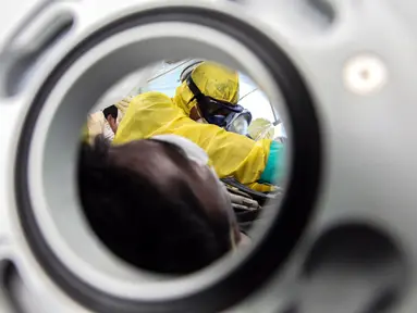 Tim medis mengisolasi pasien terinfeksi virus corona saat simulasi di Pelabuhan Belawan, Medan, Sumatera Utara, Senin (3/2/2020). Simulasi ini dilakukan untuk meningkatkan kesiapan dalam menangani pasien terinfeksi virus corona. (Ivan Damanik/AFP)