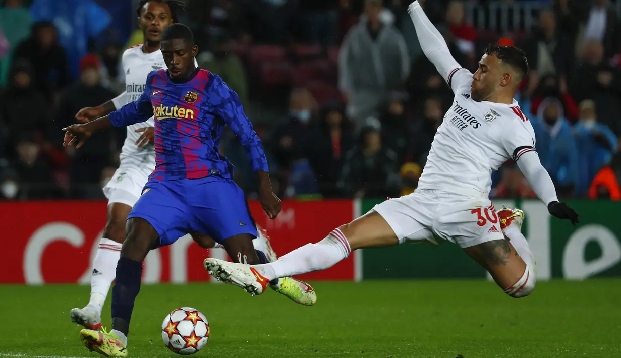 Penyerang Barcelona Ousmane Dembele (kiri) berebut bola dengan bek Benfica Nicolas Otamendi pada matchday kelima Grup E Liga Champions di Camp Nou, Rabu (24/11/2021) dini hari WIB. Barcelona hanya mampu bermain imbang 0-0 kala menjamu Benfica. (AP Photo/Joan Monfort)