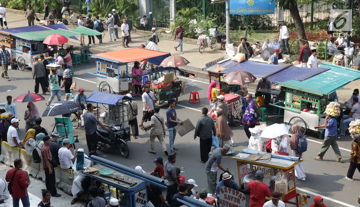 Deretan pedagang asongan berjejer di sekitaran Jalan Medan Merdeka Barat, Jakarta, Kamis (27/6/2019). Massa yang melakukan aksi terkait sidang putusan perselisihan hasil Pilpres 2019 memberi keuntungan bagi para pedagang. (Liputan6.com/Helmi Fithriansyah)