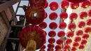 Seorang pekerja memasang lentera tradisional Tiongkok di sepanjang gang menjelang Tahun Baru Imlek di Beijing, China, 2 Februari 2021. Imlek tahun ini jatuh pada tanggal 12 Februari 2021. (NOEL CELIS/AFP)