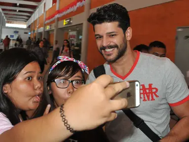 Pemeran Selim ‘Elif’, Emre Kivilcim berselfie dengan fans saat tiba di Bandara Ngurah Rai, Bali, Selasa (25/8/2015). Usai mengisi acara puncak HUT SCTV ke-25, para bintang Elif itu melanjutkan perjalanan berliburnya ke Bali. (Liputan6.com/Herman Zakharia)