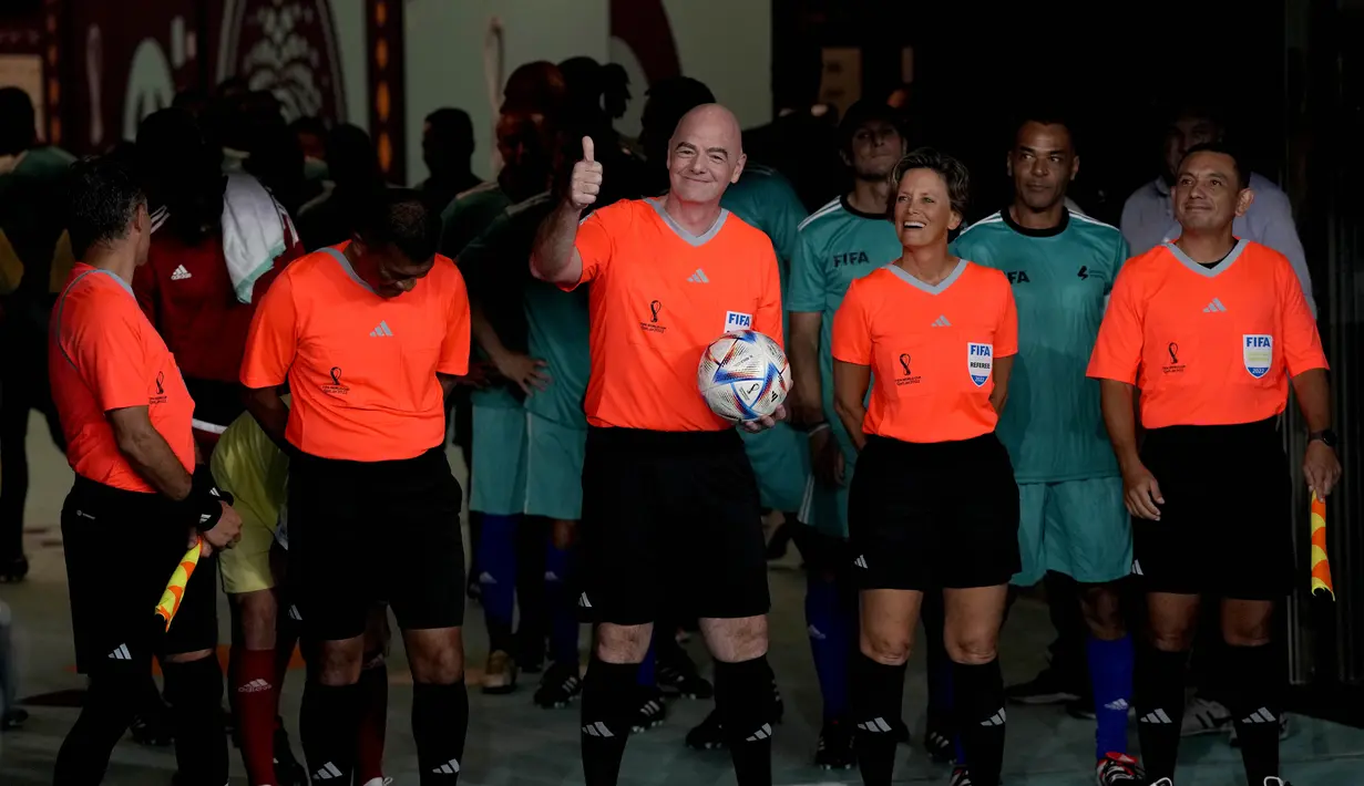 Presiden FIFA Gianni Infantino (tengah) masuk bersama wasit dan pemain untuk pertandingan persahabatan antara pekerja dan FIFA Legends di Stadion Al Thumama di Doha, Qatar, Senin (12/12/2022). Mengikuti pertandingan terakhir di FIFA Piala Dunia Qatar 2022 Stadion Al Thumama, para tamu dan sukarelawan melihat para pekerja beberapa di antaranya memenangkan edisi terakhir Piala Pekerja, bermain berdampingan dengan beberapa nama sepak bola terbesar dalam pertarungan 60 menit.(AP Photo/ Frank Augstein)
