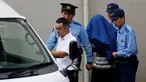 Pelaku pembantaian di sebuah panti penyandang cacat, Satoshi Uematsu (tengah) menutupi wajahnya dengan jaket saat dibawa petugas di kantor polisi Tsukui, Sagamihara, Prefektur Kanagawa, Jepang, Rabu (27/7). (REUTERS/Issei Kato)
