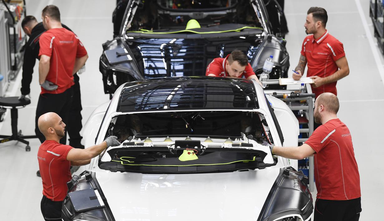 Mekanik memasangkan aksesoris mobil listrik Porsche Taycan saat proses perakitan di pabrik perusahaan Porsche AG di Stuttgart, Jerman, Rabu (4/3/2020). Porsche Taycan merupakan mobil bertenaga listrik pertama  dari pembuat mobil mewah Jerman, Porsche AG. (AFP Photo/Thomas Kienzie)