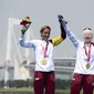 Peraih medali emas Susana Rodriguez dari Spanyol dan pemandunya Sara Loehr berpose dengan medali mereka setelah berkompetisi dalam kategori triathlon putri PTVI selama Paralympic Games Tokyo 2020 di Odaiba Marine Park di Tokyo pada 28 Agustus 2021. (CHARLY TRIBALLEAU / AFP)