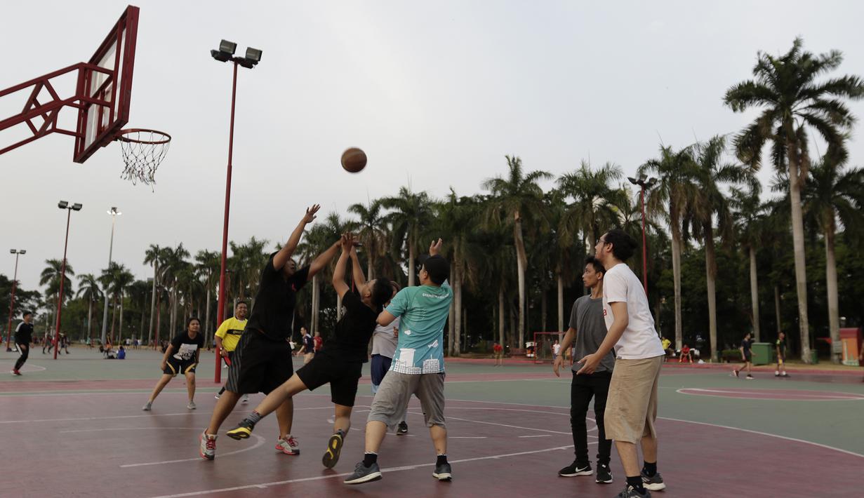 Sejumlah warga bermain basket di kawasan Monas, Jakarta, Jumat (11/10). Kawasan Monas menjadi pilihan warga Jakarta dan pekerja ibu kota untuk berolahraga sore. (Bola.com/Yoppy Renato)