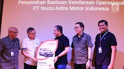 Direktur PT Isuzu Astra Motor Indonesia (IAMI) Ary A. Mariano (kedua kiri) menyerahkan bantuan kendaraan operasional kepada Yayasan Amaliah Astra Riza Deliansyah (tengah) pada puncak Astra Gema Islami (AGI) 2019 di Jakarta, Jumat (12/7/2019). (Liputan6.com/HO/Ilham)