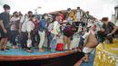 Wisatawan turun dari kapal usai liburan Tahun Baru di Pelabuhan Kali Adem, Jakarta, Minggu (2/1/2022). Wisatawan memadati Pelabuhan Kali Adem usai berlibur ke pulau-pulau kecil di utara Jakarta untuk merayakan Tahun Baru. (Liputan6.com/Faizal Fanani)