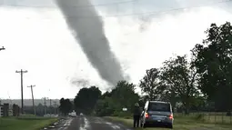 Seorang wanita mengamati tornado besar yang melewati daerah perumahan dari selatan Wynnewood, Kota Oklahoma, Senin (9/5). Tornado menelan korban sebanyak dua orang dan tiga rumah penduduk hancur. (Josh EDELSON/AFP)