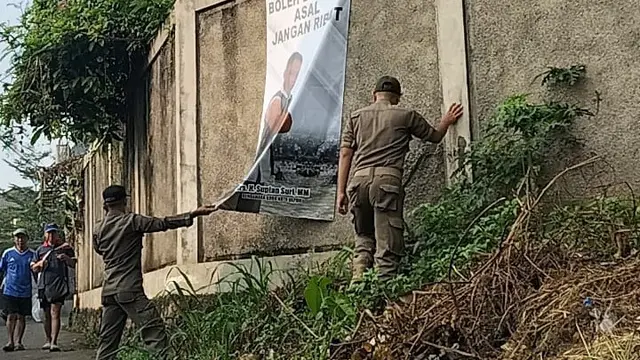 Sejumlah Satpol PP Kota Depok menurunkan spanduk Supian Suri yang terpasang kawasan Cilodong, Depok. (Istimewa)