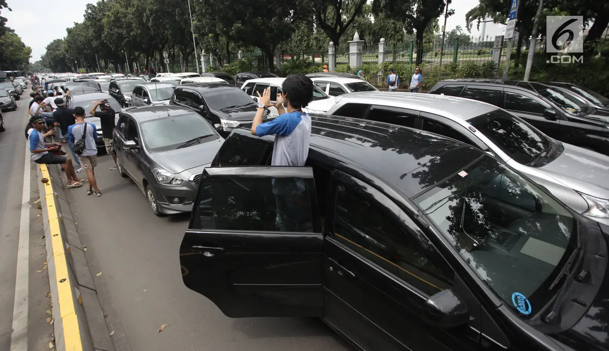 Suasana saat ratusan sopir taksi online demo di Jalan Medan Merdeka Barat, Jakarta, Rabu (14/2). Mereka menolak Permenhub Nomor 108 Tentang Penyelenggaraan Angkutan Orang Dengan Kendaraan Bermotor Umum Tidak Dalam Trayek. (Liputan6.com/Arya Manggala)