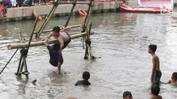 Seorang peserta terjatuh ke air saat mengikuti lomba gebuk bantal dalam Festival Kalimalang di Cipinang Melayu, Jakarta Timur, Kamis (17/8). Festival Kalimalang ini dalam rangka memeriahkan HUT ke-72 RI. (Liputan6.com/Herman Zakharia)