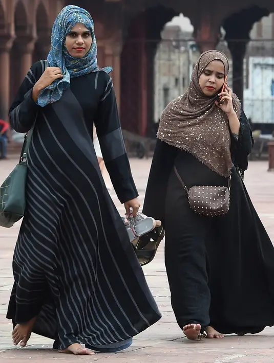Dua wanita Muslim berjalan di masjid Jama  di kawasan lama New Delhi, India (30/7/2019). Masjid Jama atau Masjid-i Jahān-Numā merupakan masjid utama yang berada di kawasan Delhi Tua di India. (AFP Photo/Money Sharma)