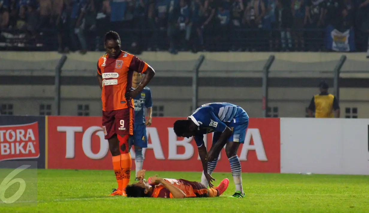 Bek Persib, Rudolf Yanto Basna (kanan) mencoba menolong pemain PBFC yang terkapar saat laga lanjutan Turnamen Piala Bhayangkara di Stadion Si Jalak Harupat, Bandung, Minggu (20/3/2016). Persib unggul 1-0 atas PBFC. (Liputan6.com/Helmi Fithriansyah)