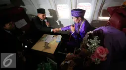 Penghulu menikahkan sepang mempelai pada prosesi nikah massal di kampus STTKD, Yogyakarta, Senin (4/4/2016). Sebanyak 21 pasangan pengantin mengikuti nikah bareng angkasa di atas pesawat boing. (Liputan6.com/Boy Harjanto)