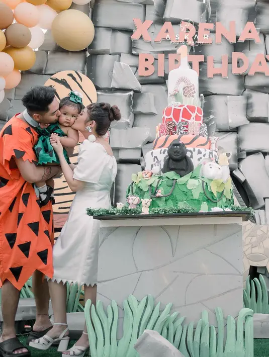 Kue ulang tahun berbentuk unik dengan beberapa tingkat dengan beragam miniatur hewan seperti kingkong, zebra, jerapah  dll. Angka 1 dipucuk menandakan ulang tahun yang pertama.  [Instagram/krisjianabah]