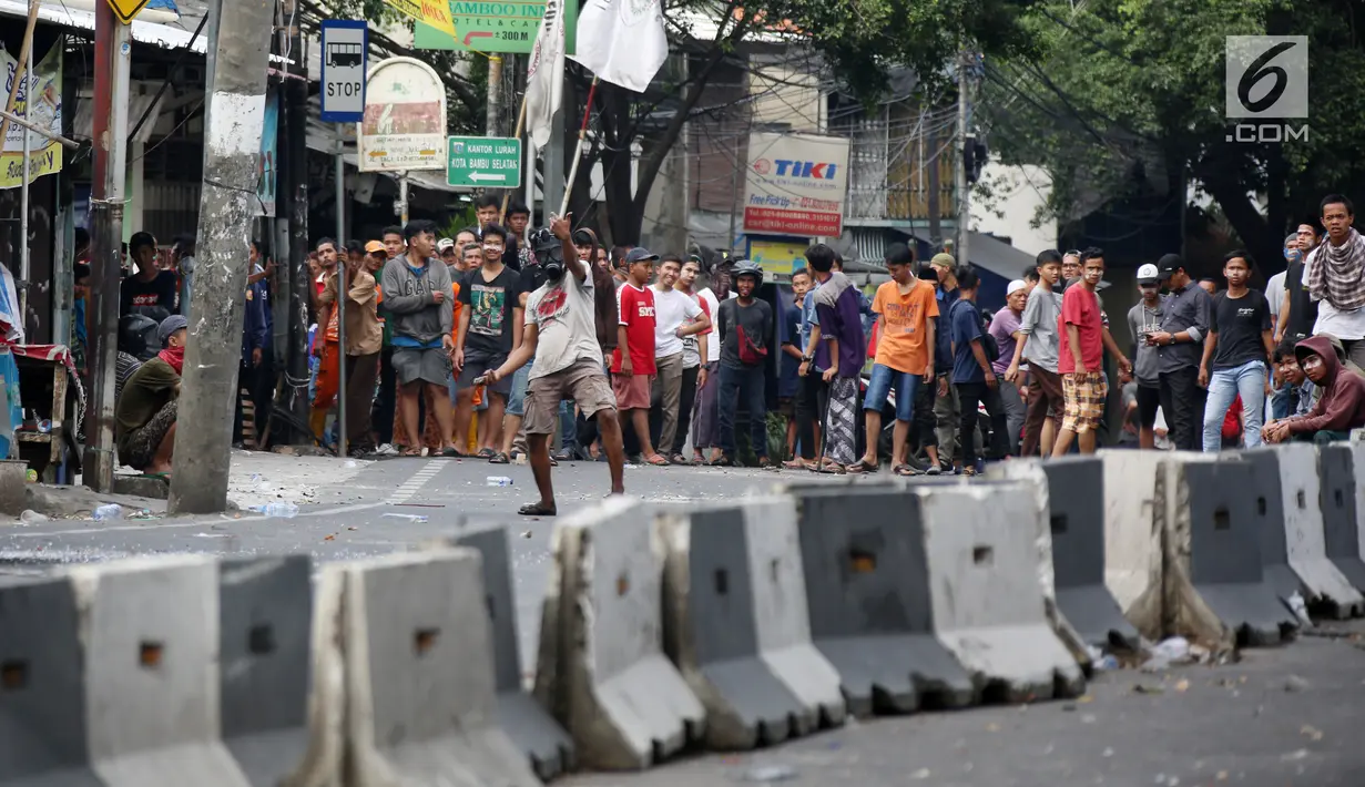 Massa bertopeng menantang aparat keamanan saat terjadi bentrok di kawasan Slipi, Jakarta Barat, Rabu (22/5/2019). Polisi membalas lemparan batu para pengunjuk rasa dengan menembakkan gas air mata. (Liputan6.com/Gempur Muhammad Surya)
