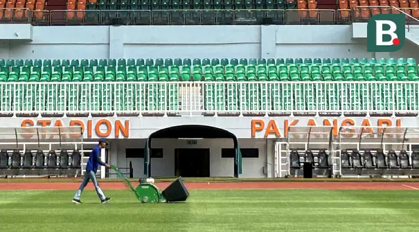 Seorang petugas melakukan perawatan rumput Stadion Pakansari, Cibinong, Kabupaten Bogor, Rabu (23/7/2026). Perawatan lapangan terus dilakukan menjelang Stadion Pakansari menjadi kandang Timnas Indonesia pada babak penyisihan Grup A Piala AFF 2026. Pengelola stadion melakukan treatment rumput sejak berakhirnya Pegadaian Championship 2025/2026 dengan pendampingan dari tim PSSI agar kondisi lapangan memenuhi standar untuk pertandingan internasional. (Bola.com/Muhammad Adi Yaksa)