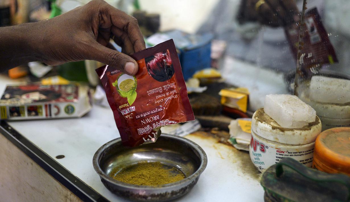 Dalam gambar yang diambil pada 19 Januari 2019, tukang cukur Mohammad Shadat Hossain menyiapkan bubuk pacar (henna) untuk diterapkan ke rambut pelanggannya di Dhaka. Pria tua Bangladesh yang ingin tetap merasa muda, menggunakan berbagai pilihan pacar (henna) yang tersedia. (MUNIR UZ ZAMAN / AFP)