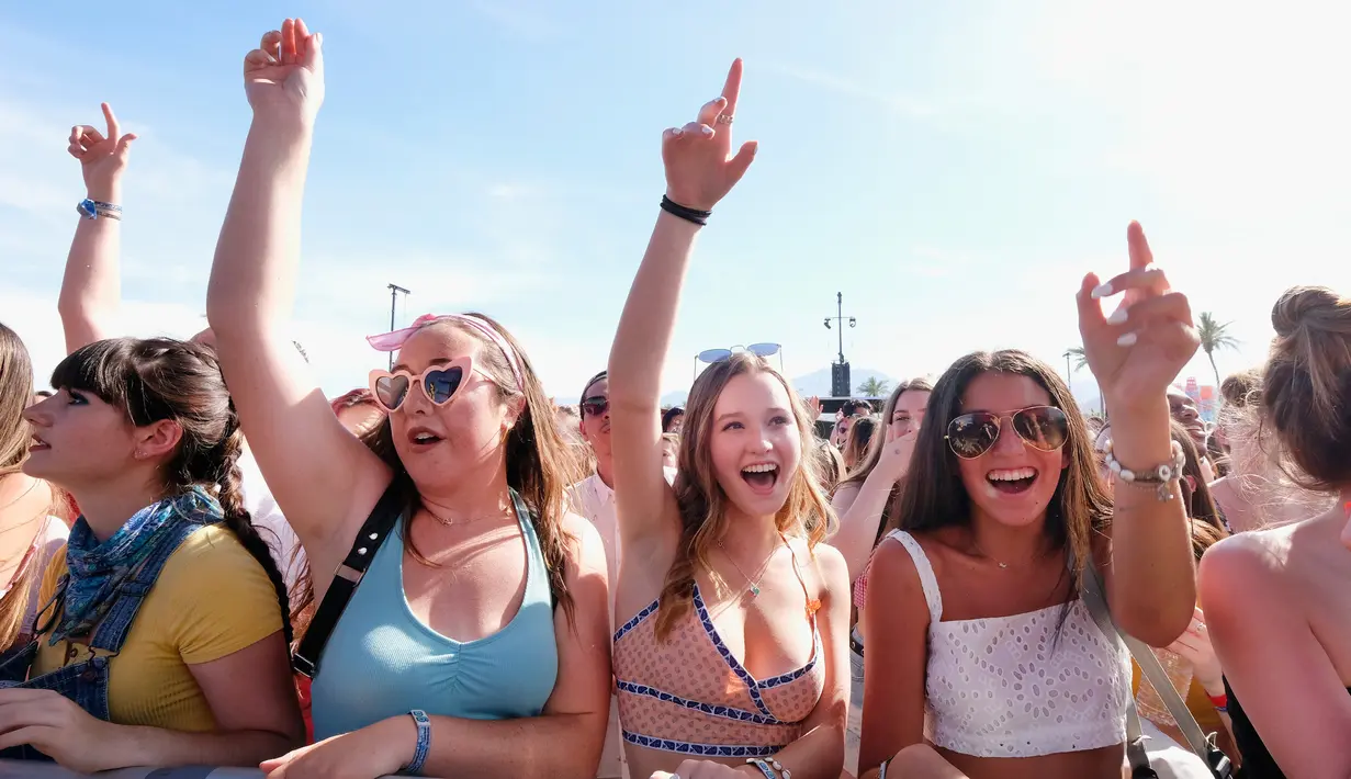 Sejumlah wanita berjoget menikmati musik selama Coachella Music & Arts Festival 2019 di Indio, California (14/4). Festival Coachella ini sudah ada sejak tahun 1999. (AFP Photo/Frazer Harrison)