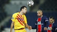 Pemain Paris Saint-Germain, Layvin Kurzawa, duel udara dengan pemain Barcelona, Sergio Busquets, pada laga Liga Champions di Stadion Parc des Princes, Kamis (11/3/2021). Kedua tim bermain imbang 1-1. (AP/Christophe Ena)