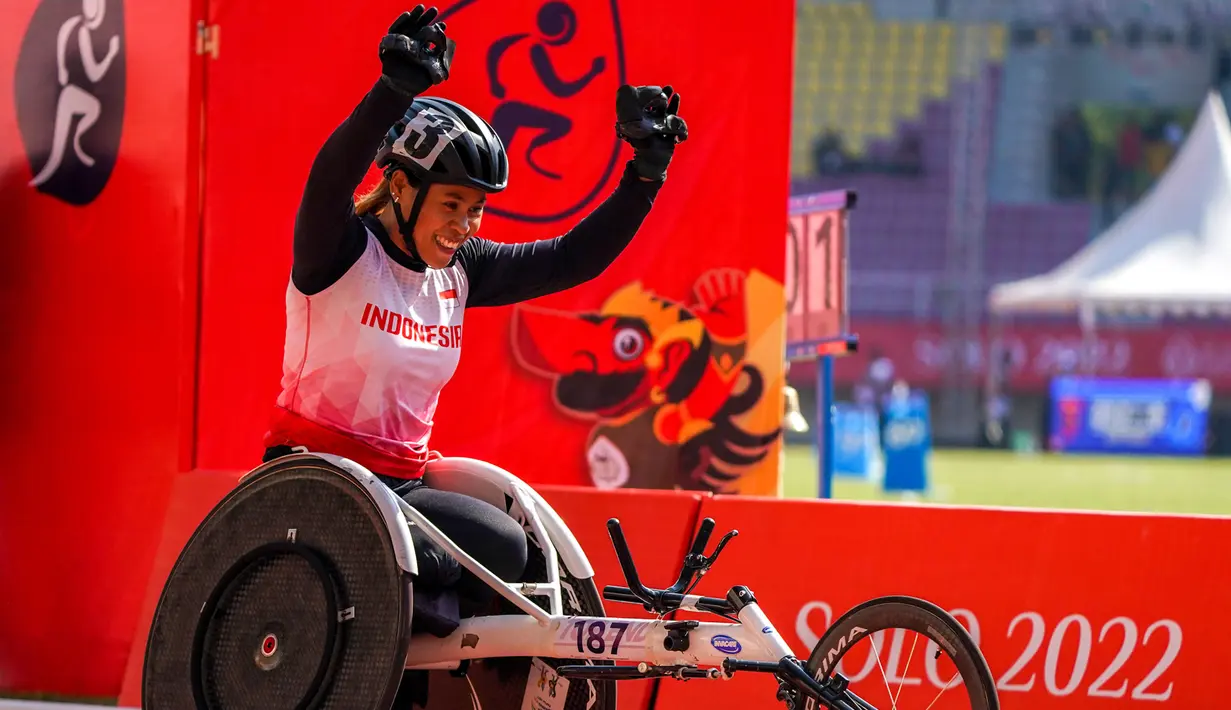Atlet balap kursi roda Maria Goreti melakukan selebrasi usai memenangi final balap kursi roda 400 meter putri 11th ASEAN Para Games 2022 di Stadion Manahan, Solo, Jawa Tengah, Kamis (4/8/2022). Maria Goreti meraih medali emas pada final tersebut. (INASPOC/Feri Setiawan)