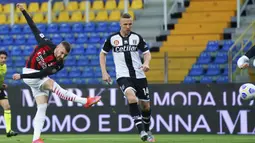 Striker AC Milan, Ante Rebic (kiri) melepaskan tendangan yang berbuah gol pertama timnya ke gawang Parma dalam laga lanjutan Liga Italia 2020/2021 pekan ke-30 di Ennio-Tardini Stadium, Parma, Sabtu (10/4/2021). AC Milan menang 3-1 atas Parma. (LaPresse via AP/Spada)