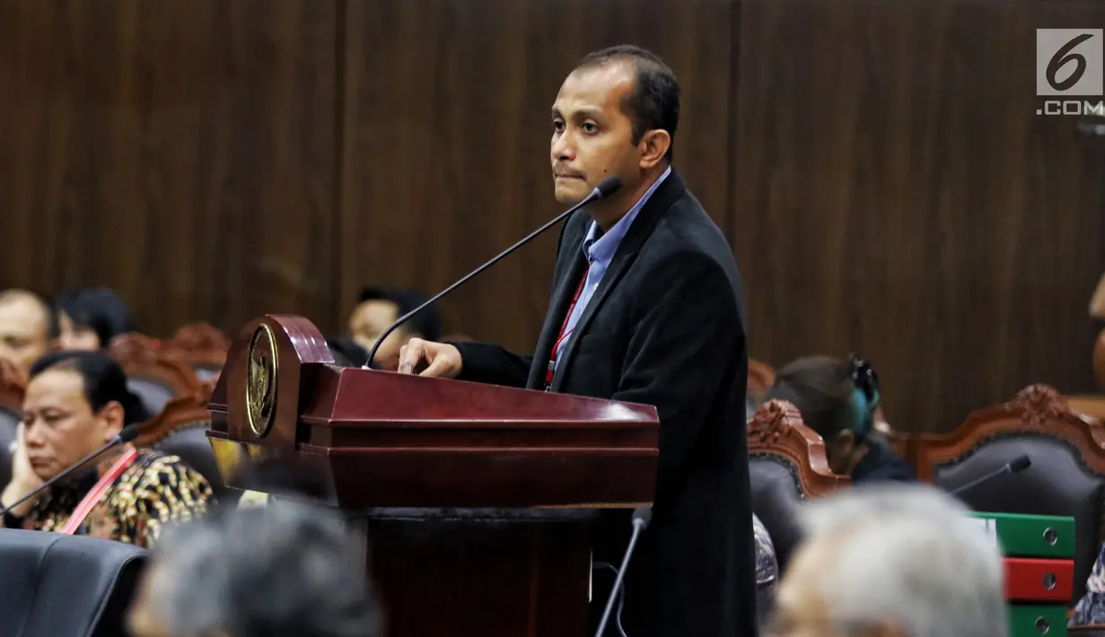 Ahli dari TKN Prof Edward Omar Syarief Hiariej saat memberi keterangan selama sidang lanjutan sengketa Pilpres 2019 di Gedung MK, Jakarta, Jumat (21/6/2019). Pokok keterangan yang disampaikan Edward terkait TSM dalam konteks UU Pemilu sebagaimana UU Nomor 7 Tahun 2017. (Liputan6.com/Johan Tallo)