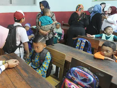 Seorang ibu menenangkan anaknya yang merajuk saat hari pertama masuk sekolah di SDN Cinere 1, Depok, Jawa Barat, Senin (15/7/2019). Seluruh siswa SD, SMP dan SMA, pada hari ini mulai masuk sekolah pada tahun ajaran baru 2019/2020. (merdeka.com/Arie Basuki)