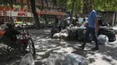 Seorang pria berjalan melewati tumpukan sampah akibat pemogokan petugas sampah di Santiago (14/11/2019). Protes kekerasan meletus di ibukota Chile, Santiago, pada Selasa ketika mata uang negara itu turun ke level terendah dalam sejarah. (AFP/Javier Torres)