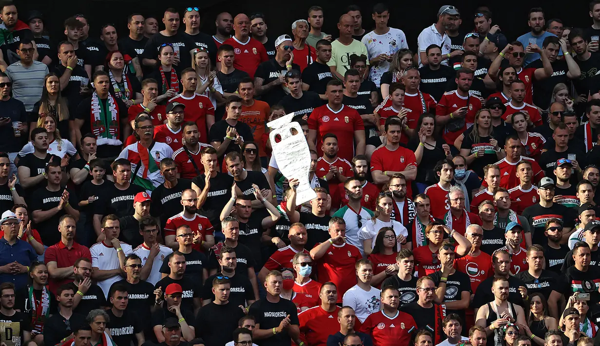 Suporter timnas Hungaria memegang replika trofi EURO pada pertandingan grup F Euro 2020 melawan Portugal di Puskas Arena di Budapest, Selasa (15/6/2021). Pertandingan yang dimenangkan oleh Portugal 3-0 itu dihadiri lebih dari 60.000 penonton atau kapasitas maksimal Stadion (BERNADETT SZABO/POOL/AFP)