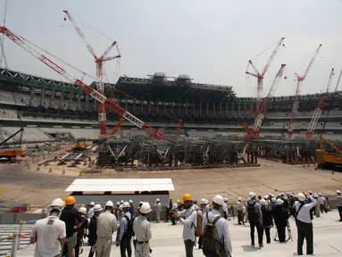 Wartawan mengunjungi New National Stadium yang dalam pembangunan pada tur media ke sejumlah venue Olimpiade Tokyo 2020 di Tokyo, Rabu (18/7). Dewan Olahraga Jepang mengatakan proyek ini sudah mencapai 40 persen jelang upacara pembukaan. (AP/Koji Sasahara)