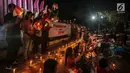Massa aksi tergabung dalam Pencinta NKRI dan Pancasila menyalakan lilin dengan mengibarkan bendera merah putih untuk Papua di Tugu Proklamasi, Menteng, Jakarta, Selasa (20/8/2019).  Aksi dengan doa bersama sebagai bentuk solidaritas untuk perdamaian di Tanah Papua. (Liputan6.com/Faizal Fanani)