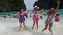 Turis melompat di atas ombak pantai Maya Bay di pulau Phi Phi Leh, Thailand, Kamis (31/5). Maya Bay akan ditutup untuk memulihkan terumbu karang yang sakit akibat peningkatan suhu serta pencemaran lingkungan oleh pengunjung. (AP Photo/Sakchai Lalit)