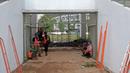 Pekerja berteduh saat hujan sebelum melanjutkan renovasi venue Atletik Stadion Madya di Kawasan Senayan Sport Center, Jakarta (12/10/2017). Renovasi tersebut menyambut Asian Games 2018. (Bola.com/Nicklas Hanoatubun)