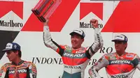 Pebalap Repsol Honda asal Jepang Tadayuki Okada (tengah) mengangkat trofi dengan pebalap Repsol Honda asal Australia Mick Doohan (kanan) dan pebalap Repsol Honda asal Spanyol Alex Criville (kiri) pada World Championship Marlboro Indonesian Grand Prix di Sirkuit Sentul, 28 September 1997. (STR/AFP)