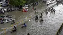 Para pengendara mendorong kendaraannya saat melewati jalan yang banjir di Karachi, Pakistan, Kamis (23/9/2021). Banjir merendam Karachi setelah diguyur hujan deras. (AP Photo/Fareed Khan)