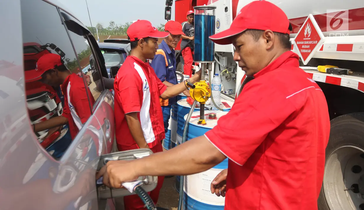 Petugas melakukan pengisian BBM untuk kendaraan pemudik di Rest Area KM 344 Tol Fungsional Pemalang-Batang, Jawa Tengah, Senin (11/6). Selama arus mudik Lebaran 2018, PT Pertamina menyediakan kios BBM. (Liputan6.com/Arya Manggala)