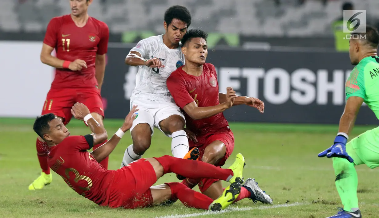 Tiga pemain Timnas Indonesia berusaha menahan pemain Timor Leste pada laga penyisihan grup B Piala AFF 2018 di Stadion GBK, Jakarta, Selasa (13/11). Babak pertama berakhir imbang 0-0. (Liputan6.com/Helmi Fithriansyah)