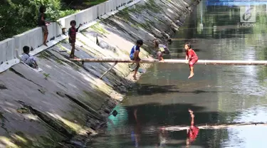 Anak-anak bermain di sungai di Jakarta, Sabtu (7/4). Gubernur DKI Jakarta Anies Baswedan memastikan akan tetap membangun Ruang Terbuka Hijau (RTH). RTH yang dimaksud yakni membangun Taman Maju Bersama dan Taman Pintar. (Liputan6.com/Angga Yuniar)