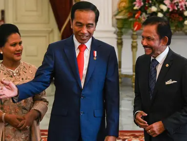 Presiden  Joko Widodo bersama ibu negara Iriana menyambut  Sultan Brunei Hassanal Bolkiah di Istana Merdeka, Minggu (20/10/2019). Sultan Brunei Darussalam Hassanal Bolkiah menjadi tamu negara pertama yang diterima oleh Jokowi. (AFP Photo/Bay Ismoyo)
