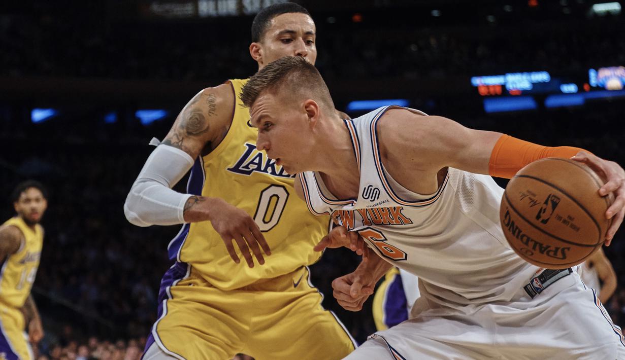 Pemain New York Knicks, Kristaps Porzingis (kiri) mencoba melewati adangan pemain Lakers, Kyle Kuzma pada lanjutan NBA basketball game di Madison Square Garden, New York, (12/12/2017). knicks menang 113-109. (AP/Andres Kudacki)