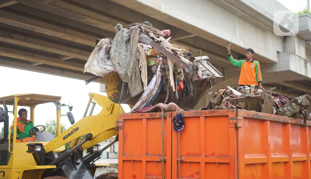 Petugas menggunakan alat berat untuk mengangkut sampah sisa banjir yang menumpuk di kawasan Cipinang Melayu, Jakarta, Senin (6/1/2020). Banjir yang menggenangi Jakarta dan sekitarnya sejak 1 Januari 2020 lalu menyisakan tumpukan sampah di sejumlah titik. (Liputan6.com/Immanuel Antonius)
